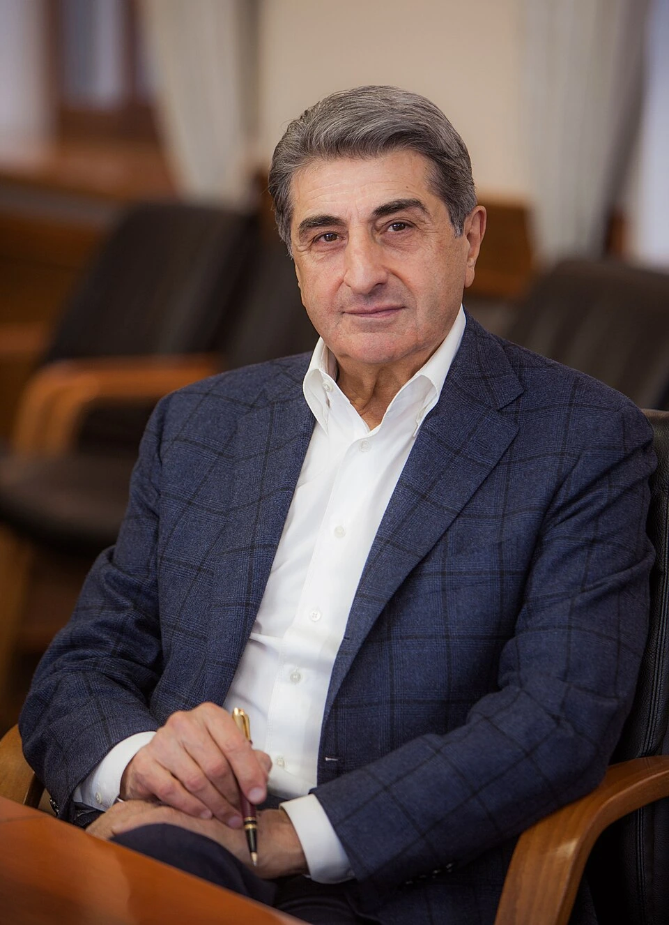 Portrait of Levan Vasadze seated indoors in a suit and white shirt.
