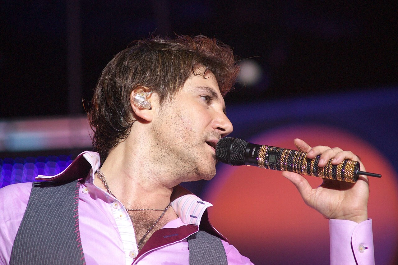 Avraam Russo performing on stage with a microphone